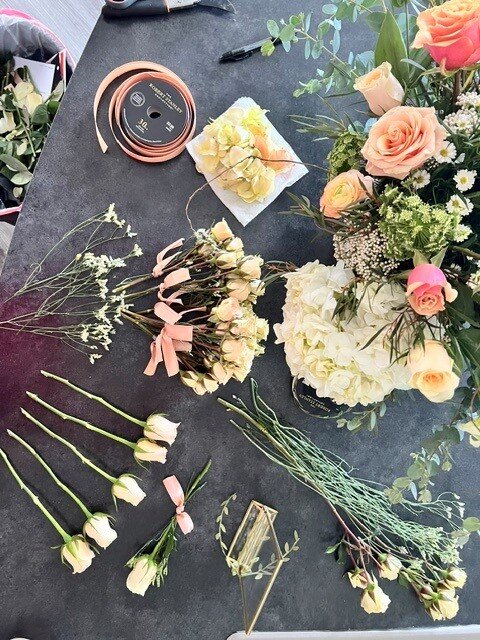 Flowers and ribbon laid out during arrangement prep